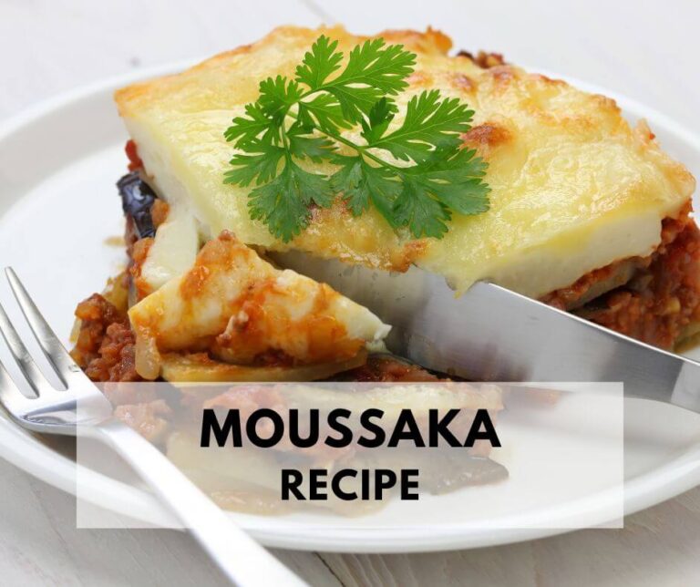Moussaka on a white plate with fork and knife.